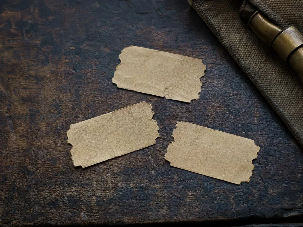 Three torn paper ticket stubs on a scratched wooden counter
